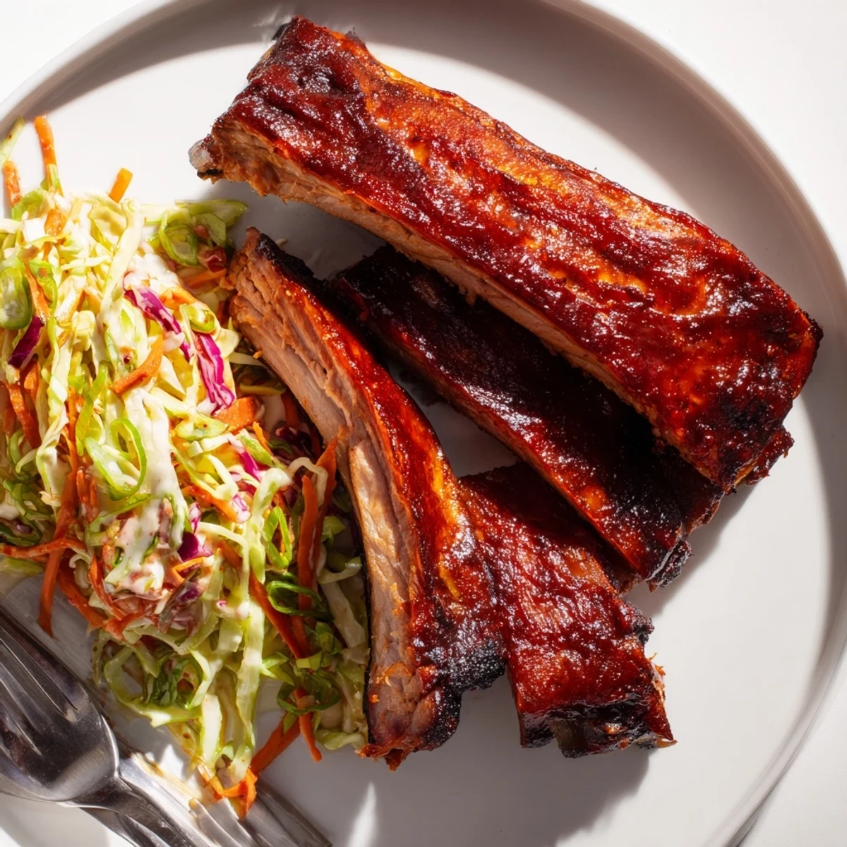 Tender Slow Cooker BBQ Ribs drizzled with smoky sauce and paired with fresh slaw.  
