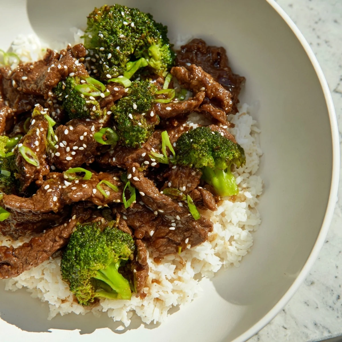 Enjoy slow simmering: A flavorful Slow-Cooker Beef & Broccoli recipe, garnished with scallions and seeds.