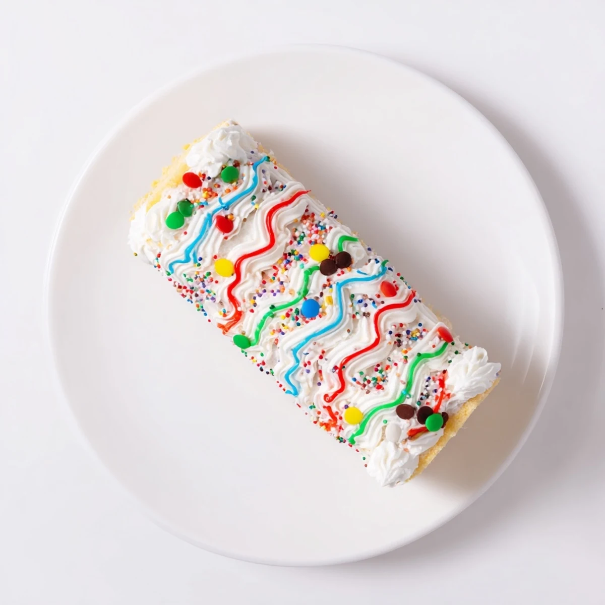 Close-up of a colorful Ugly Sweater Cake Roll, frosted with whimsical designs and bright sprinkles.