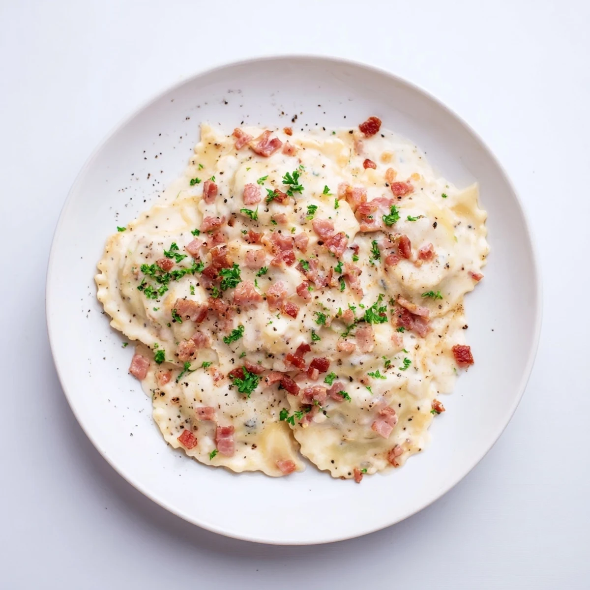A close-up of Olive Garden Ravioli Carbonara: rich pasta coated in a decadent, savory cream sauce.