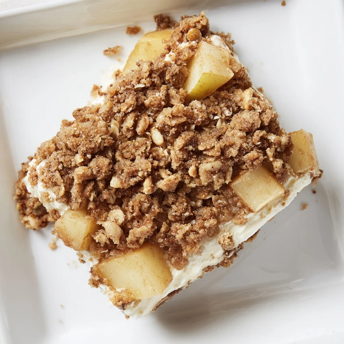 Close-up of freshly baked Apple Crisp Cheesecake Bars, showing layers of creamy cheese and apples.