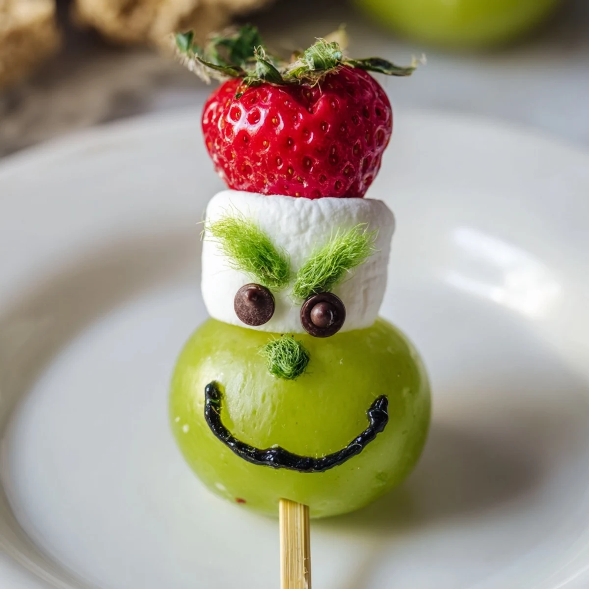 Sweet Grinch faces made with green grapes and marshmallows, a fun, festive holiday snack.
