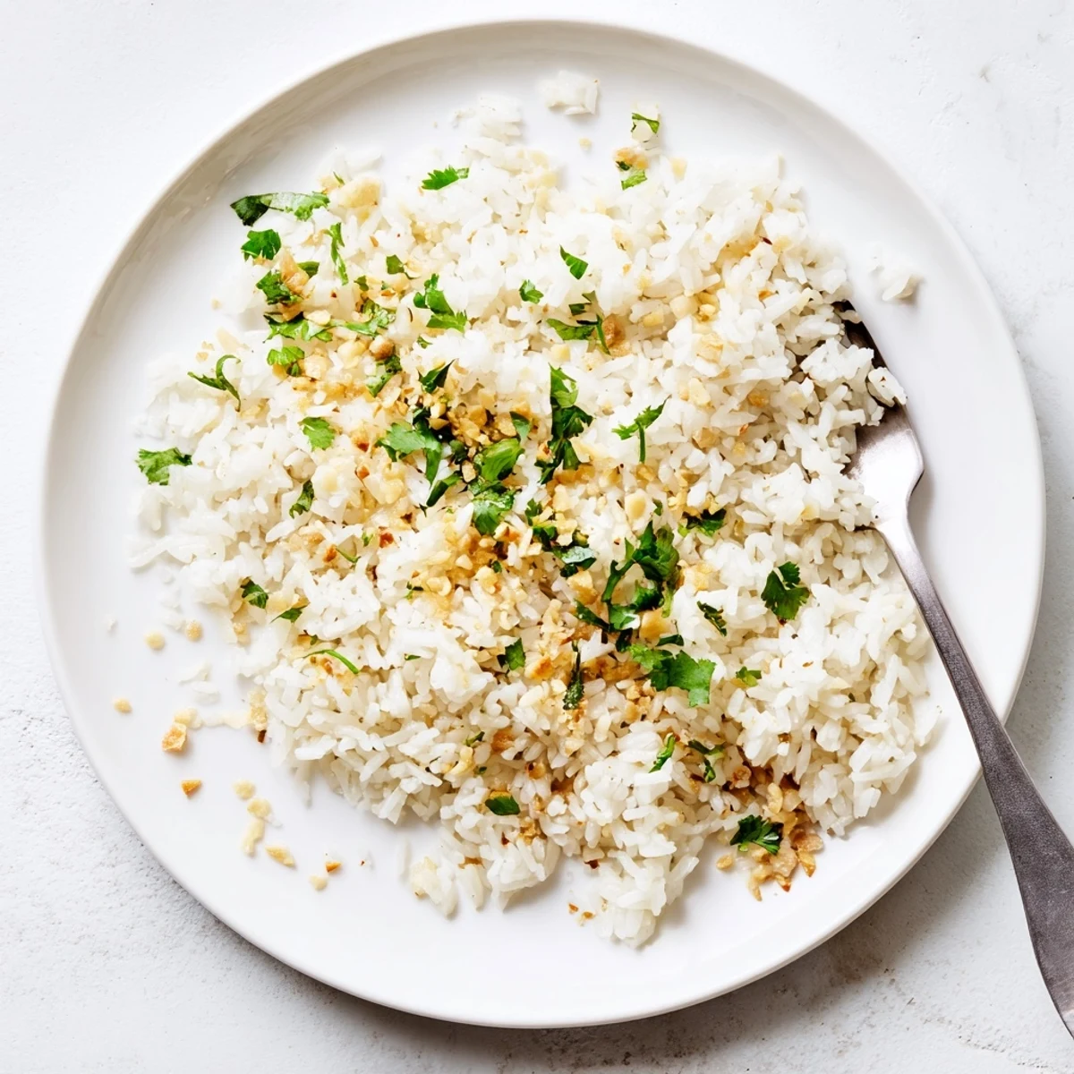 Golden garlic oil coats fluffy Jasmine Rice, ready to serve as a vegan side for dinner.