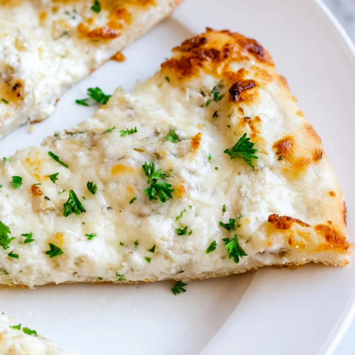 Sliced Creamy Garlic White Pizza on a cutting board with a side salad and wine.