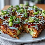 Golden fried rice squares layered with creamy avocado, zesty spicy tuna, and crunchy vegetables in a vibrant bowl.  