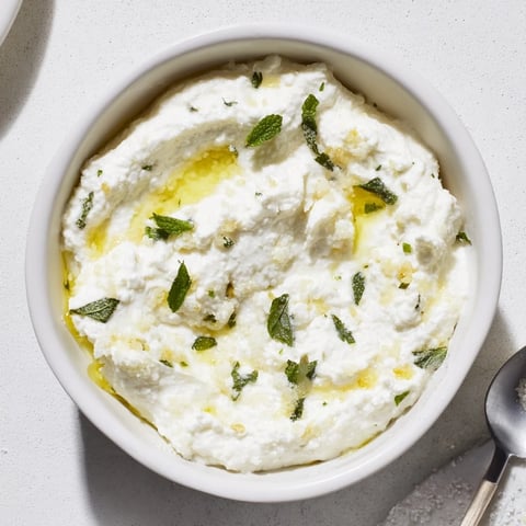Creamy whipped feta dip with vibrant lemon-mint drizzle, ideal for dipping pita.