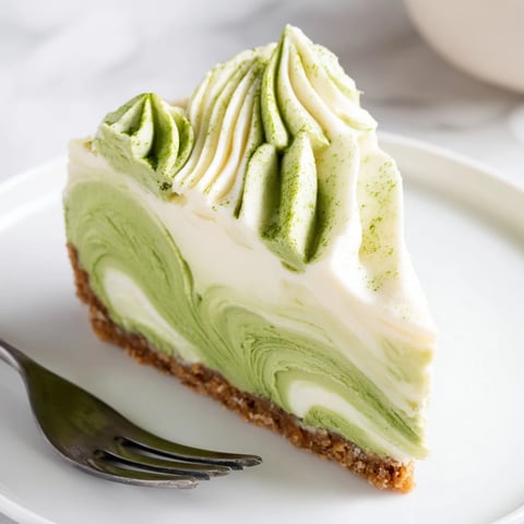 A close-up shot of decadent Matcha Swirl Snowdrift Cheesecake Cups swirled with vibrant green and creamy white.