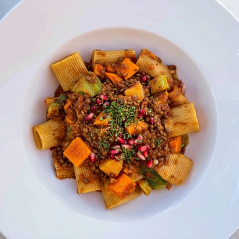 Steaming bowl of High-Fiber Lentil Bolognese over pasta, garnished with fresh parsley and Parmesan.