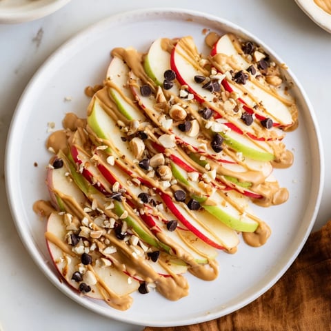 Crisp apple slices covered in peanut butter, forming delicious and easy peanut butter apple nachos.