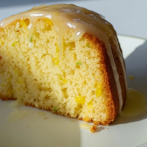 Fluffy lemon yogurt cake, glazed and sliced, perfect for a sunny afternoon snack or dessert.