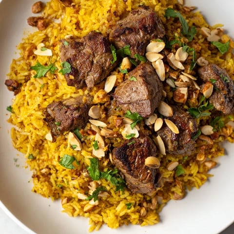 Steaming, fluffy Qatari Majboos—fragrant basmati rice surrounds tender lamb, ready to serve this classic dish.