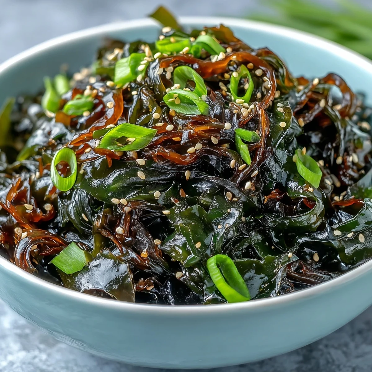 Vibrant seaweed salad with ponzu dressing, sesame seeds, and crisp vegetables in a Japanese-inspired dish.  