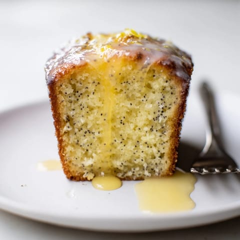 Freshly baked mini lemon poppy seed loaves with a crunchy poppy seed texture.  