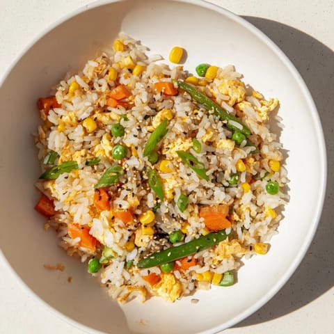 Delicious, colorful Frozen Veggie Fried Rice with egg and a sprinkle of sesame seeds, ready to enjoy.