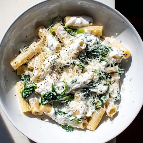 A steaming dish of Whipped Ricotta & Spinach Baked Pasta, perfect for a cozy, comforting, cheesy dinner entree.