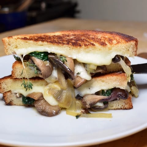 A close-up shot of a perfectly grilled Roast Garlic Mushroom & Thyme Grilled Cheese, bread toasted to perfection.