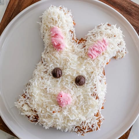 Whimsical spring bunny carrot cake, featuring detailed coconut fur, ready for a delicious dessert.