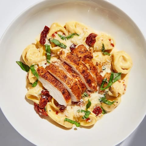 A close-up of Marry Me Chicken Tortellini shows the creamy sauce coating the pasta and shredded chicken.