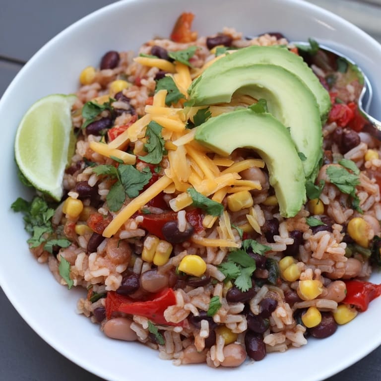 Savory One-Pan Mexican Rice and Beans, garnished with fresh cilantro and lime wedges.  