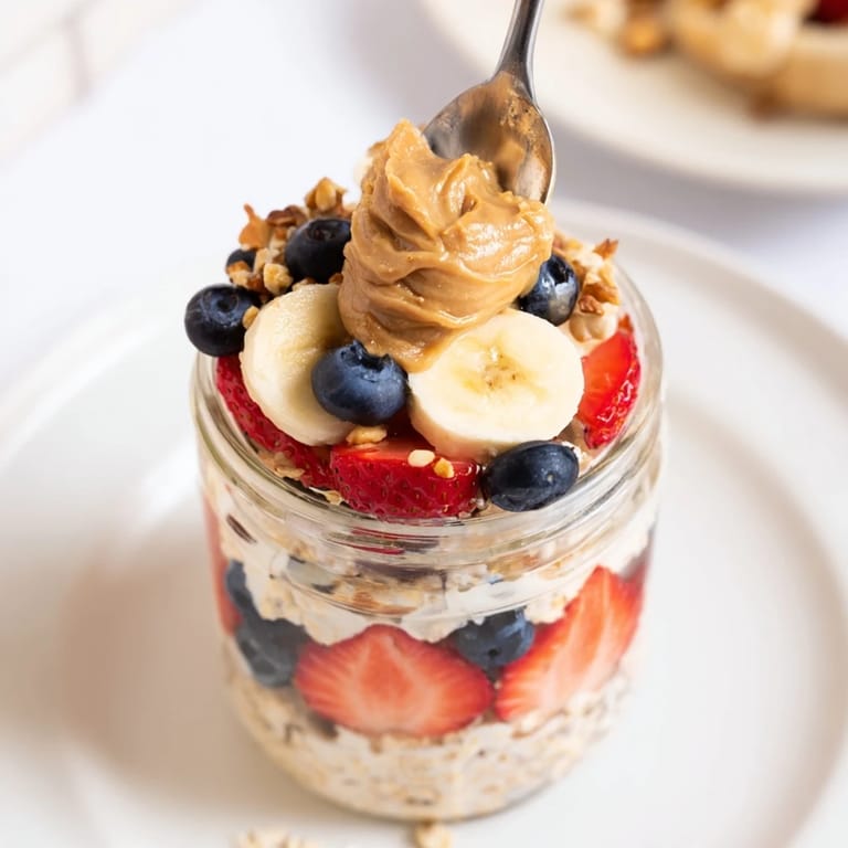 Mouthwatering image of overnight oats jars: a healthy breakfast layered with vibrant fruit and nuts.