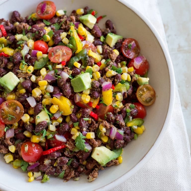 This colorful Dense Southwestern Bean Salad shows off black beans, chicken, and corn, ready to eat.