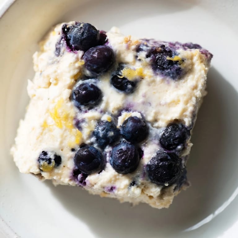 Fresh blueberries nestled in a fluffy Blueberry Cottage Cheese Bake, perfect for meal prep.
