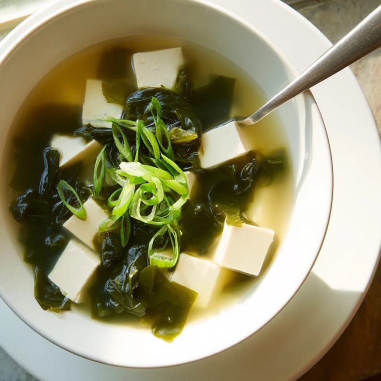 A simple, nourishing bowl of traditional Miso Soup With Tofu features probiotic miso broth, silky tofu, vibrant green scallions, and tender seaweed, perfect as a healthy starter.