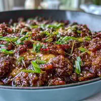 Golden melted cheddar blankets the Keto BBQ Bacon Cheeseburger Skillet, with crispy bacon bits and diced onions peeking through the rich sauce.